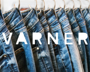 VARNER logo superimposed over many models of jeans from different denim, texture, color hang on hangers